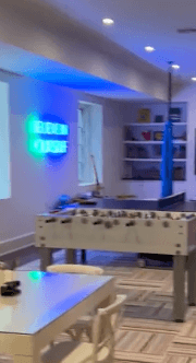Brite Lite Tribe be kind neon sign glowing in a modern game room setting