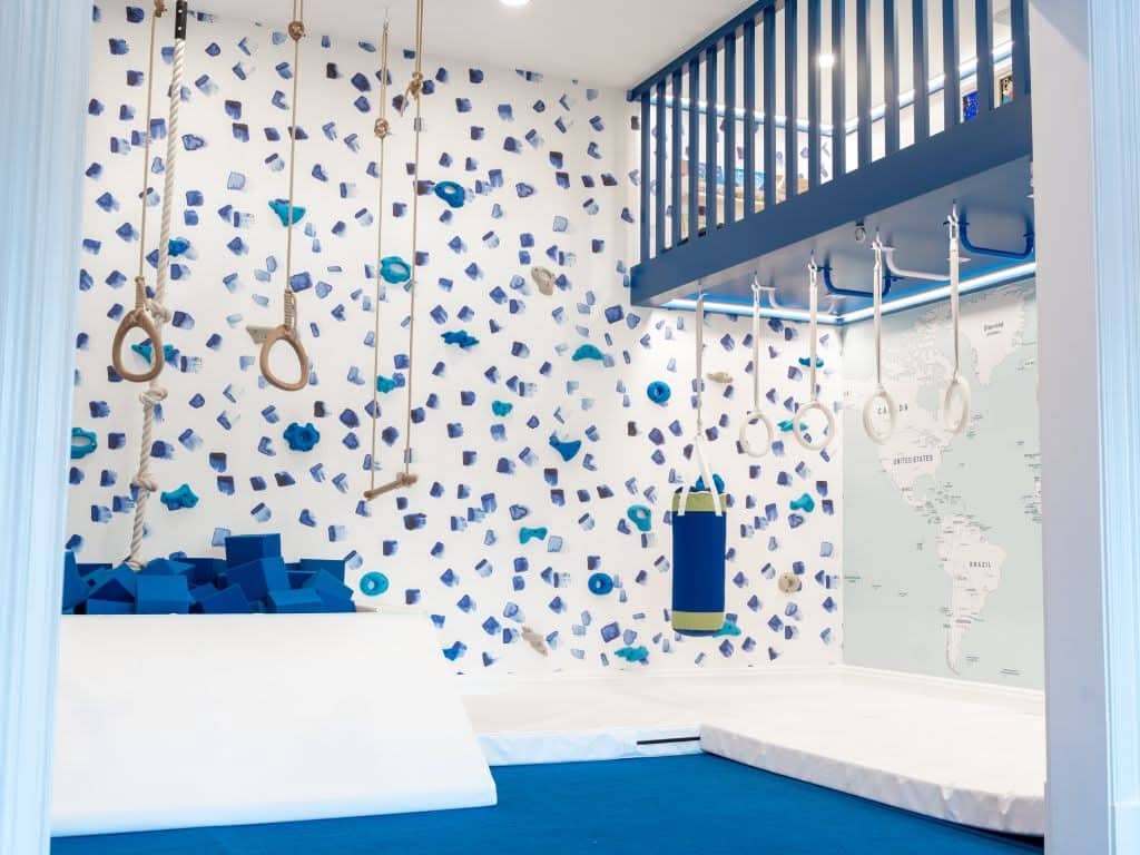Climbing playroom design package featuring a colorful climbing wall and safety mats for kids