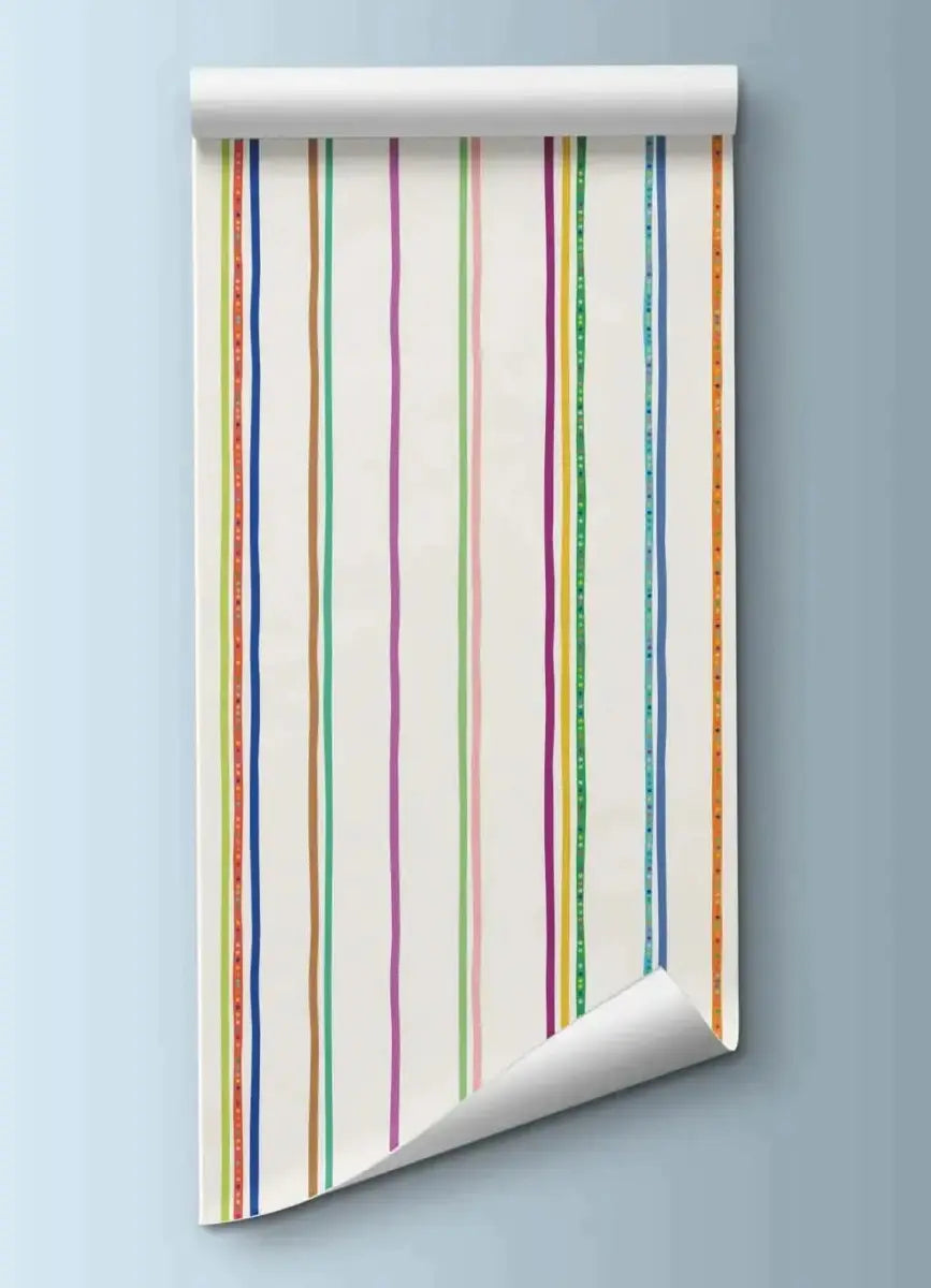Colorful striped wallpaper for playrooms rolled down on a light blue wall, featuring vibrant stripes