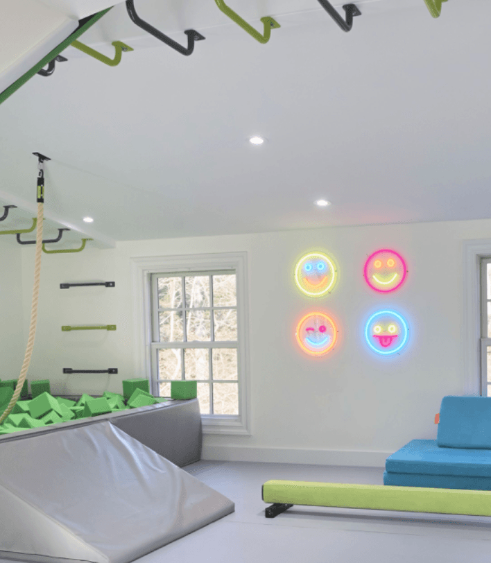 Brite Lite Tribe neon signs featuring colorful smiley faces illuminating a playful indoor space