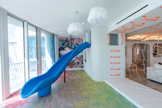 Indoor monkey bars for kids featured in a colorful playroom with a slide and modern decor