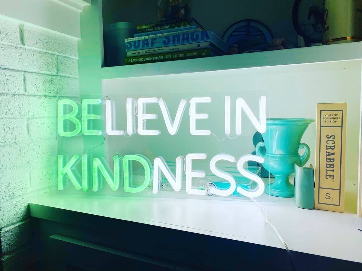 Brite Lite Tribe be kind neon sign glowing softly in a home setting to promote positivity