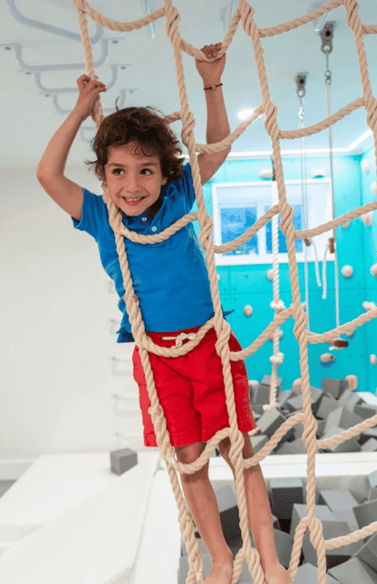 Child climbing on Jammar climbing cargo net for playroom in a fun indoor setting