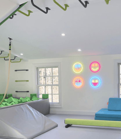 Brite Lite Tribe neon signs featuring colorful smiley faces illuminating a playful indoor space