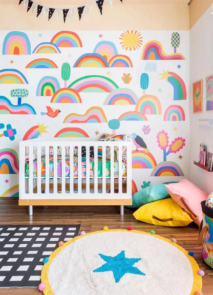 Colorful rainbow wallpaper for playroom featuring cheerful clouds, flowers, and playful designs