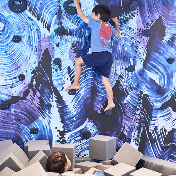 Swirl wallpaper for playroom featuring vibrant blue patterns, perfect for children's climbing areas