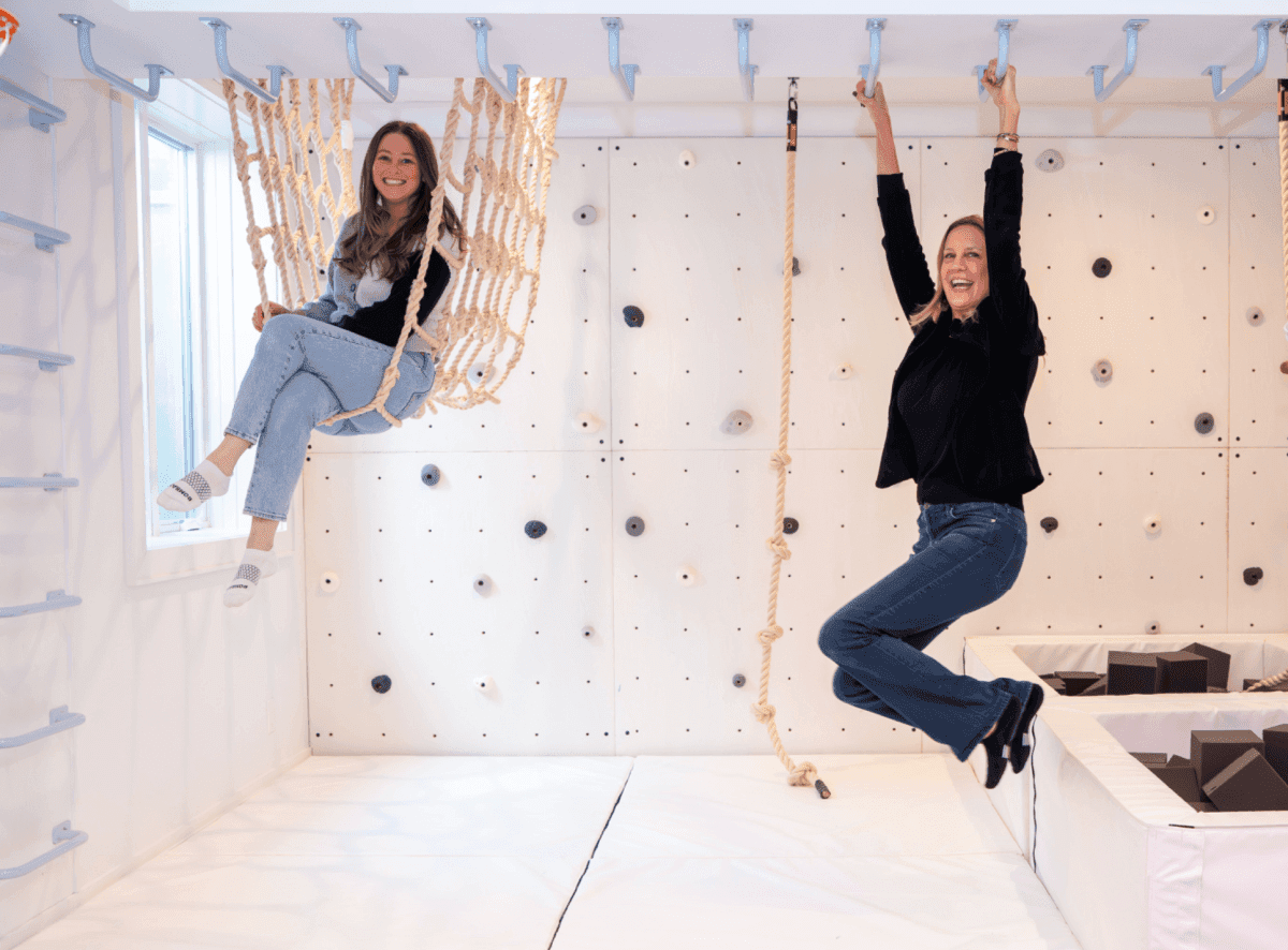 Two women enjoying the Jammar U-Tunnel Net for playrooms, featuring climbing elements and swings